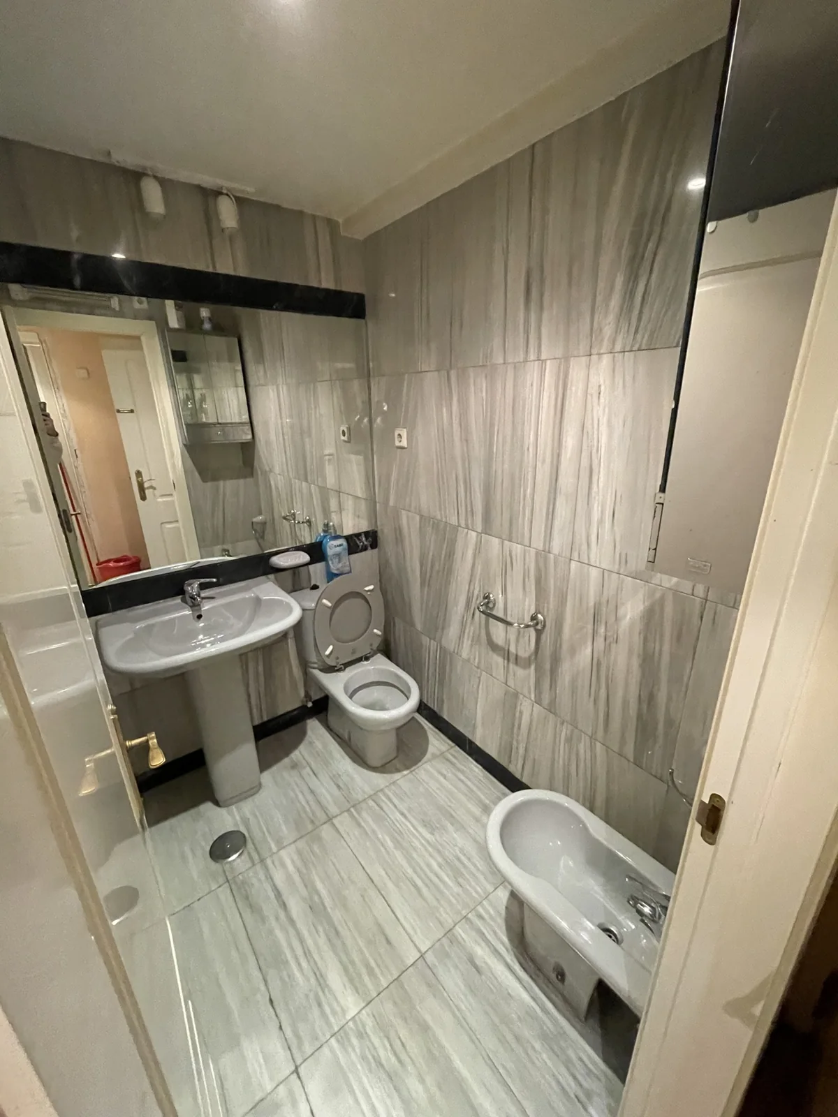 El mismo baño de Madrid centro antes de la reforma, con bañera y suelo anterior