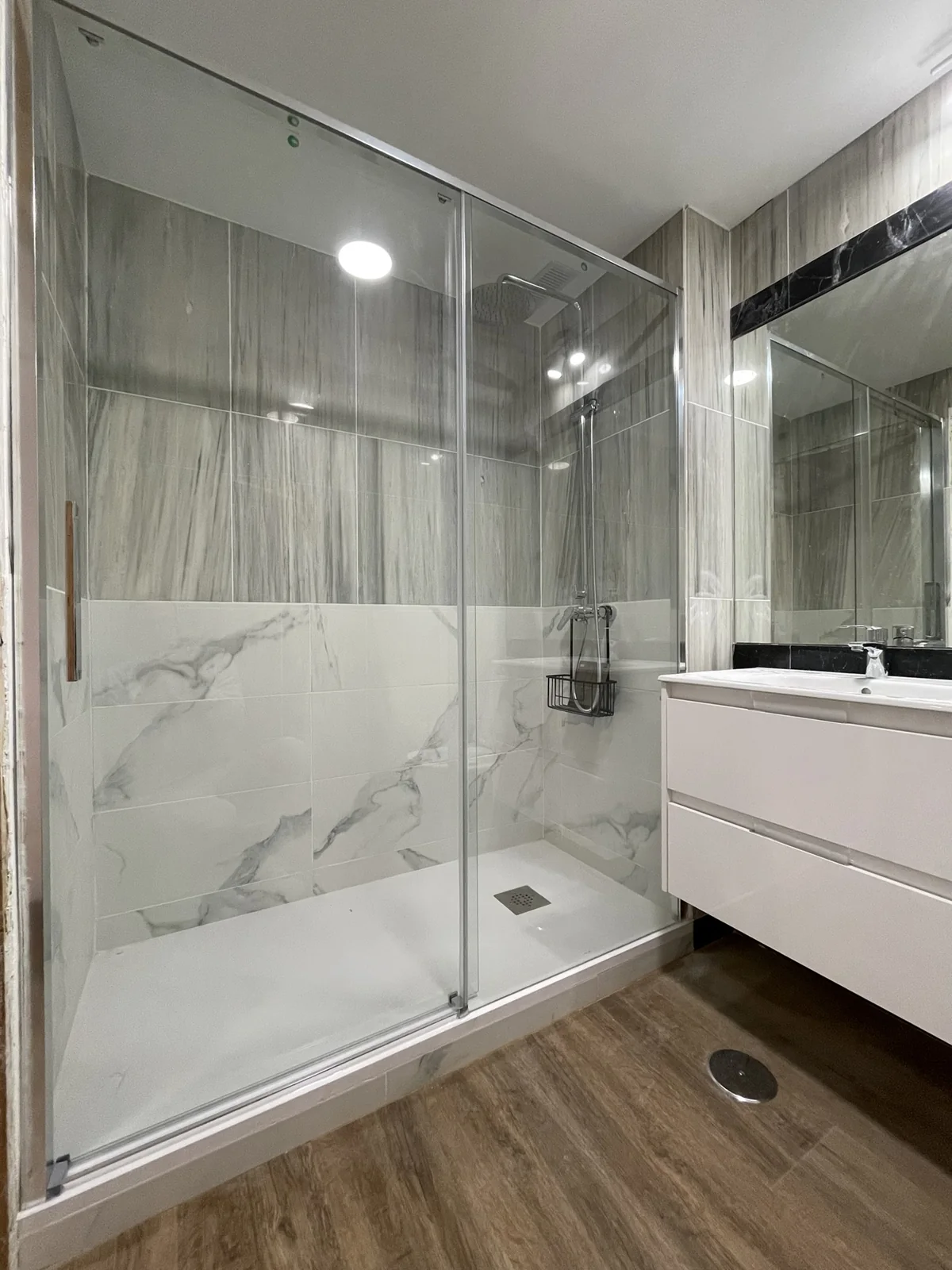 Ducha y mueble de lavabo tras la instalación de la mampara.